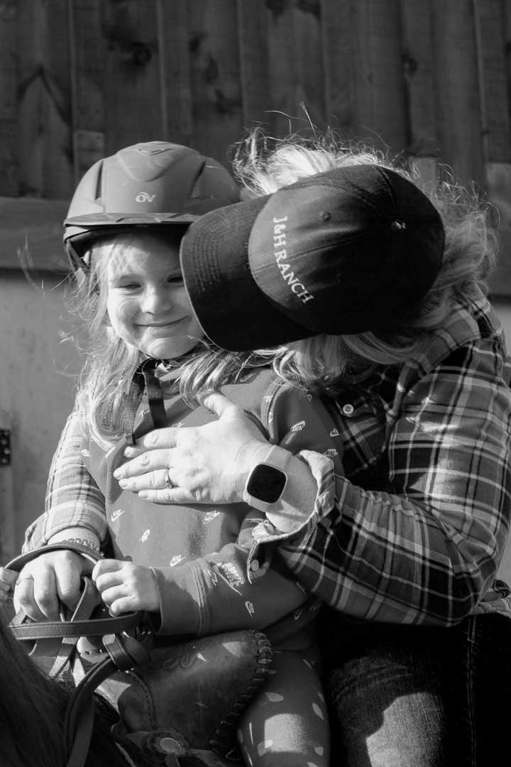 A young girl sitting on a horse smiling